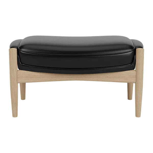 Black leather ottoman with light wooden legs, featuring a smooth, curved design. Perfect for modern interiors.