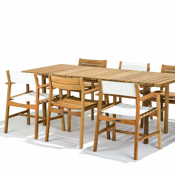 Natural wood table with six matching light-colored chairs featuring simple, clean lines for a modern look.