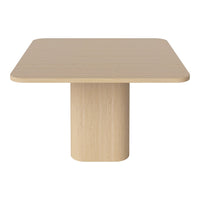 Light beige square table with a smooth, matte finish and a cylindrical pedestal base. Simple, modern design.