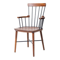 Stylish wooden chair with a warm brown seat and black metal accents, featuring a minimalist spindle back design.