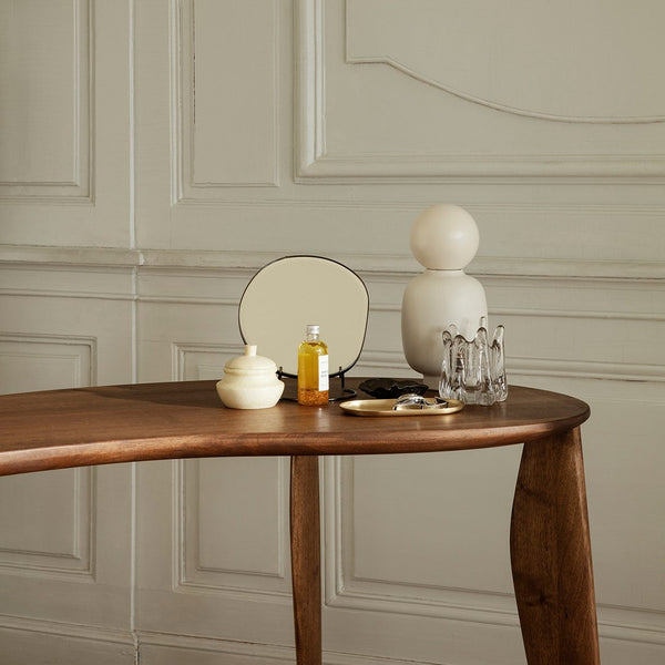 Elegant wooden table with neutral tones, creamy white accessories, and smooth, minimalist patterns against a soft backdrop.