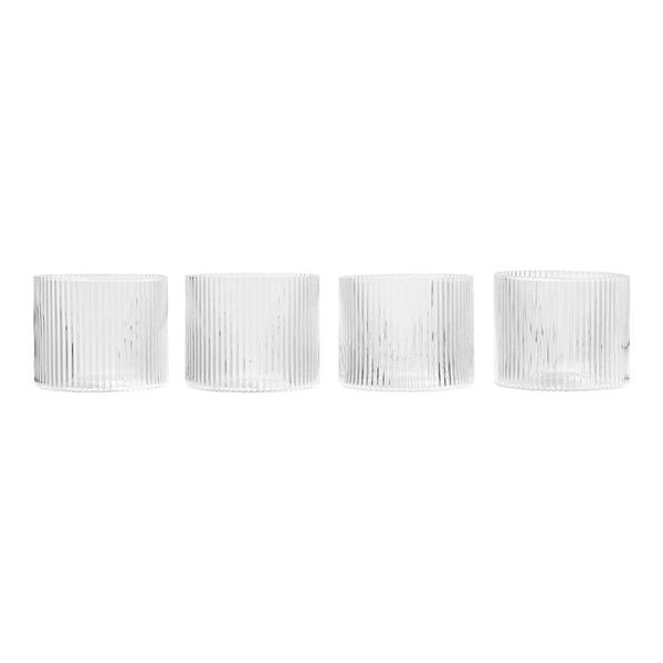 Set of four clear glass candle holders with ribbed texture and minimalist design. Perfect for elegant decor.