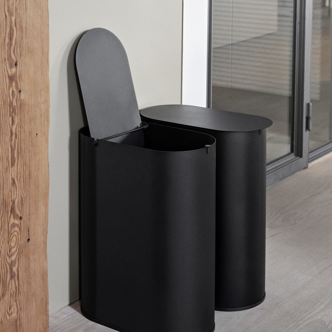 Sleek black metal waste bins with smooth, rounded edges and minimalist design, ideal for modern decor.