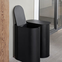 Sleek black metal waste bins with smooth, rounded edges and minimalist design, ideal for modern decor.