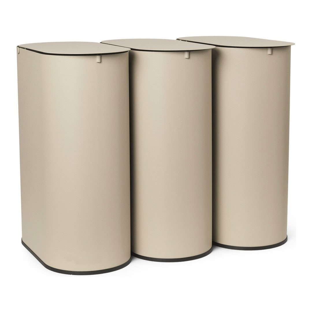 "Set of three cylindrical storage bins in a soft beige tone with sleek, minimalist design and dark base accents."