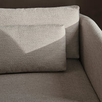 Light beige textured upholstery on a modern sofa with soft, rounded edges and minimalist design.