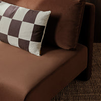 Brown sofa with a stylish black and white checkered pillow, creating a modern and cozy look. Perfect for contemporary decor.