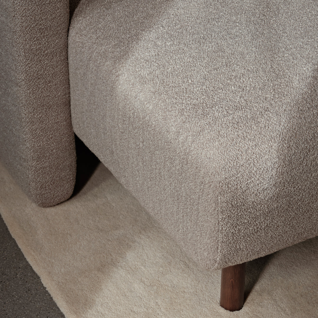Soft beige textured fabric with a subtle pattern, complemented by warm wooden legs. Ideal for modern interiors.