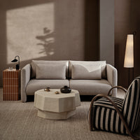 Neutral-toned modern sofa with soft textures, paired with a geometric coffee table and striped armchair.