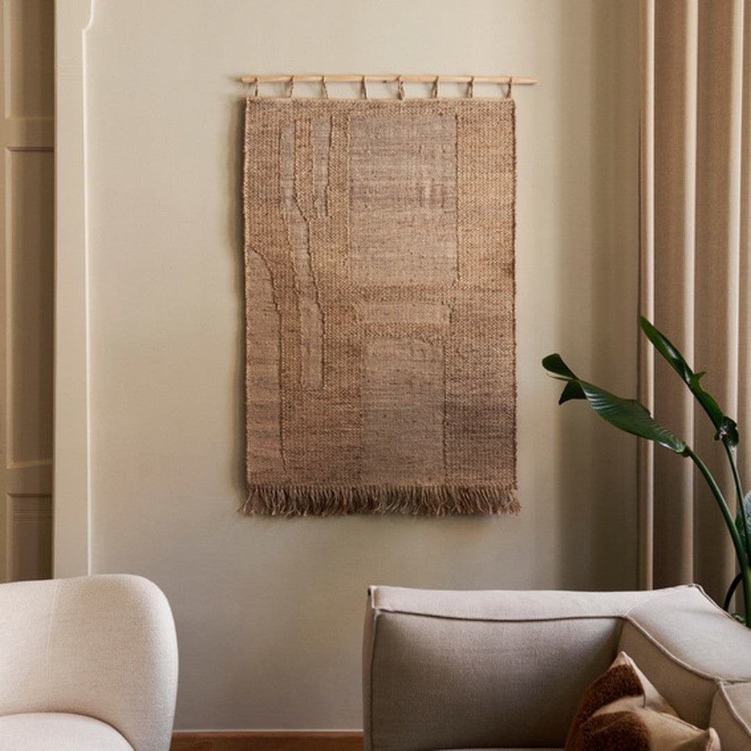 Textured beige wall hanging with subtle patterns and fringed edges, complementing neutral interior decor.