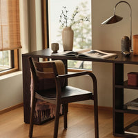 "Modern wooden desk with a neutral palette, striped throw, and soft beige curtains, creating a warm, inviting workspace."