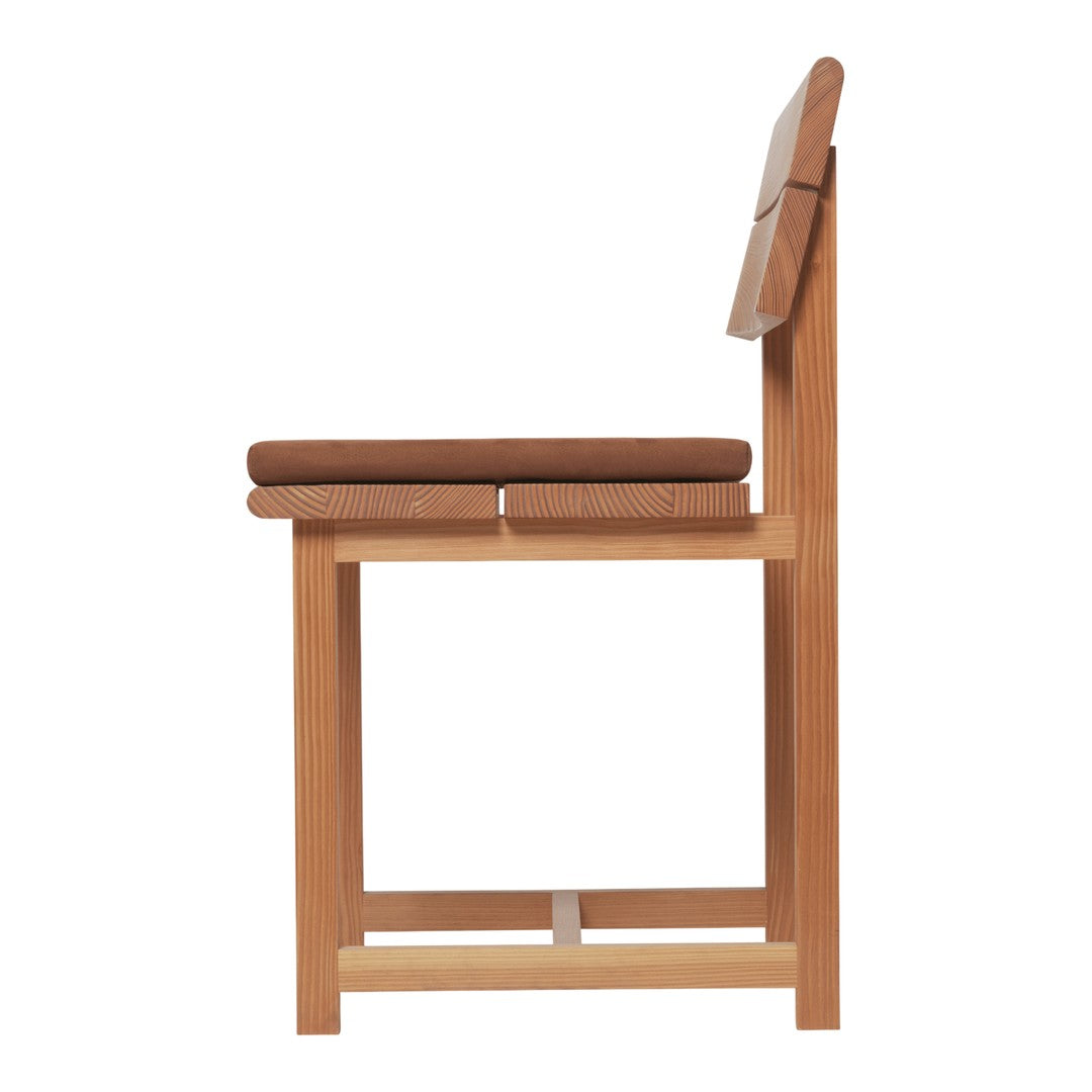 Side view of a wooden chair with a light natural finish and a rich brown cushioned seat. Simple, modern design.