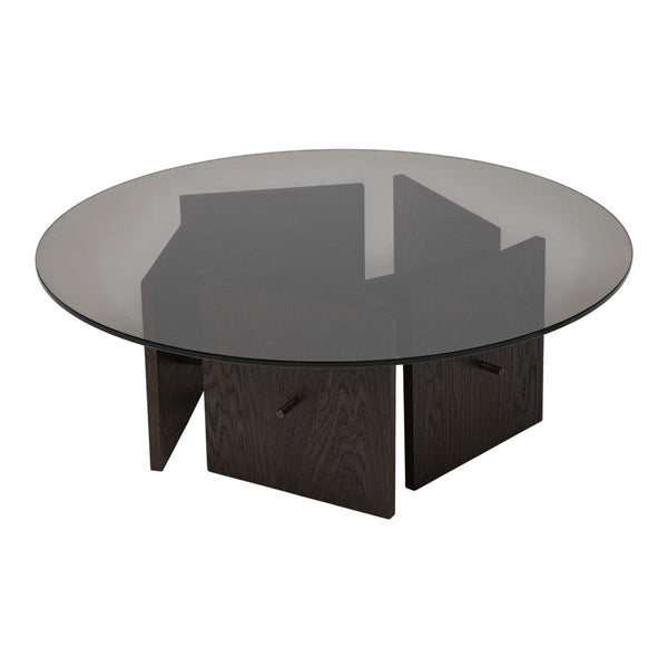 Round coffee table featuring a smoky glass top and dark wood geometric base. Sleek, modern design with elegant contrasts.
