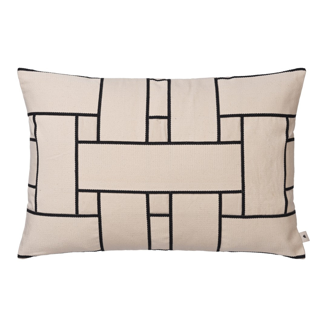 Beige decorative pillow with black geometric pattern and grid design on a smooth fabric surface.
