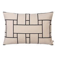Beige decorative pillow with black geometric pattern and grid design on a smooth fabric surface.