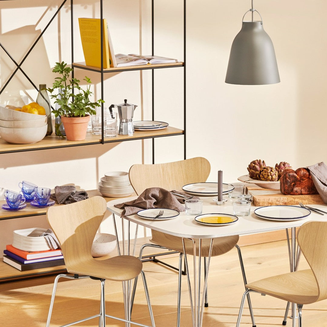 "Modern dining set featuring light wood tones, neutral gray accents, and soft blue pattern on tableware."