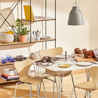 "Modern dining set featuring light wood tones, neutral gray accents, and soft blue pattern on tableware."