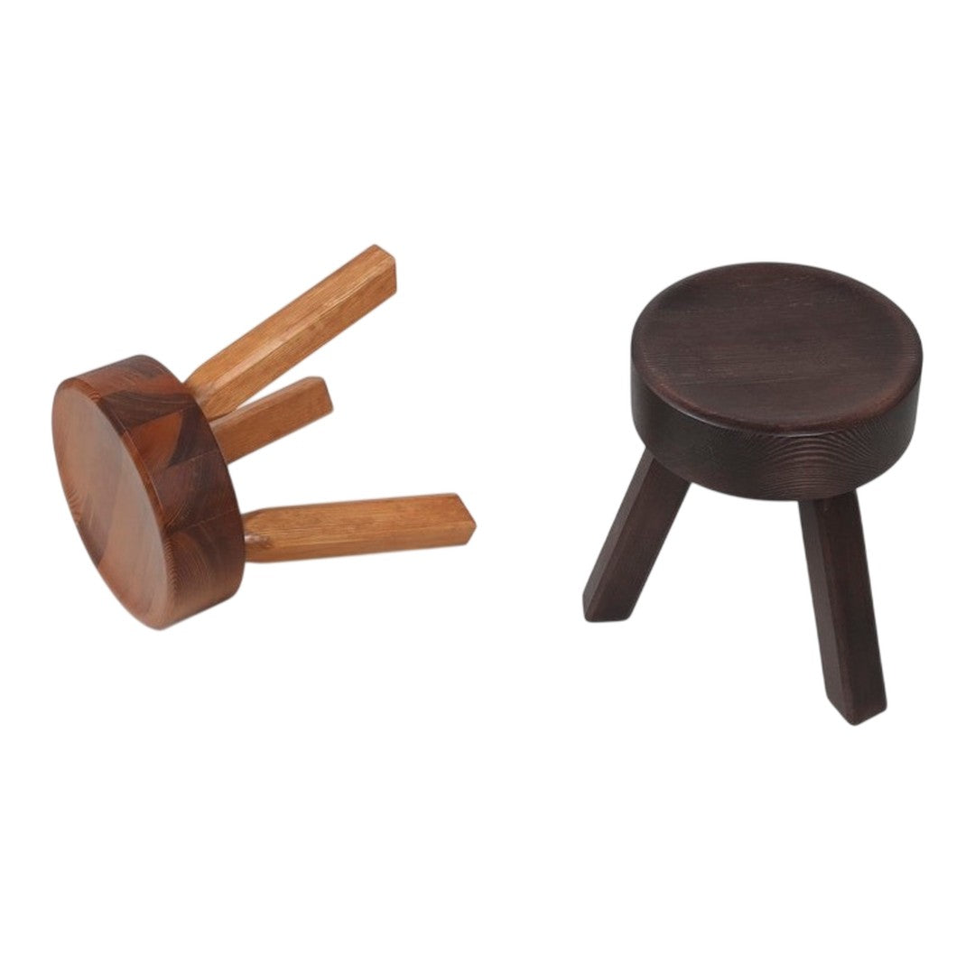 "Stylish wooden stools in dark and light brown finishes, showcasing smooth surfaces and simple shapes."