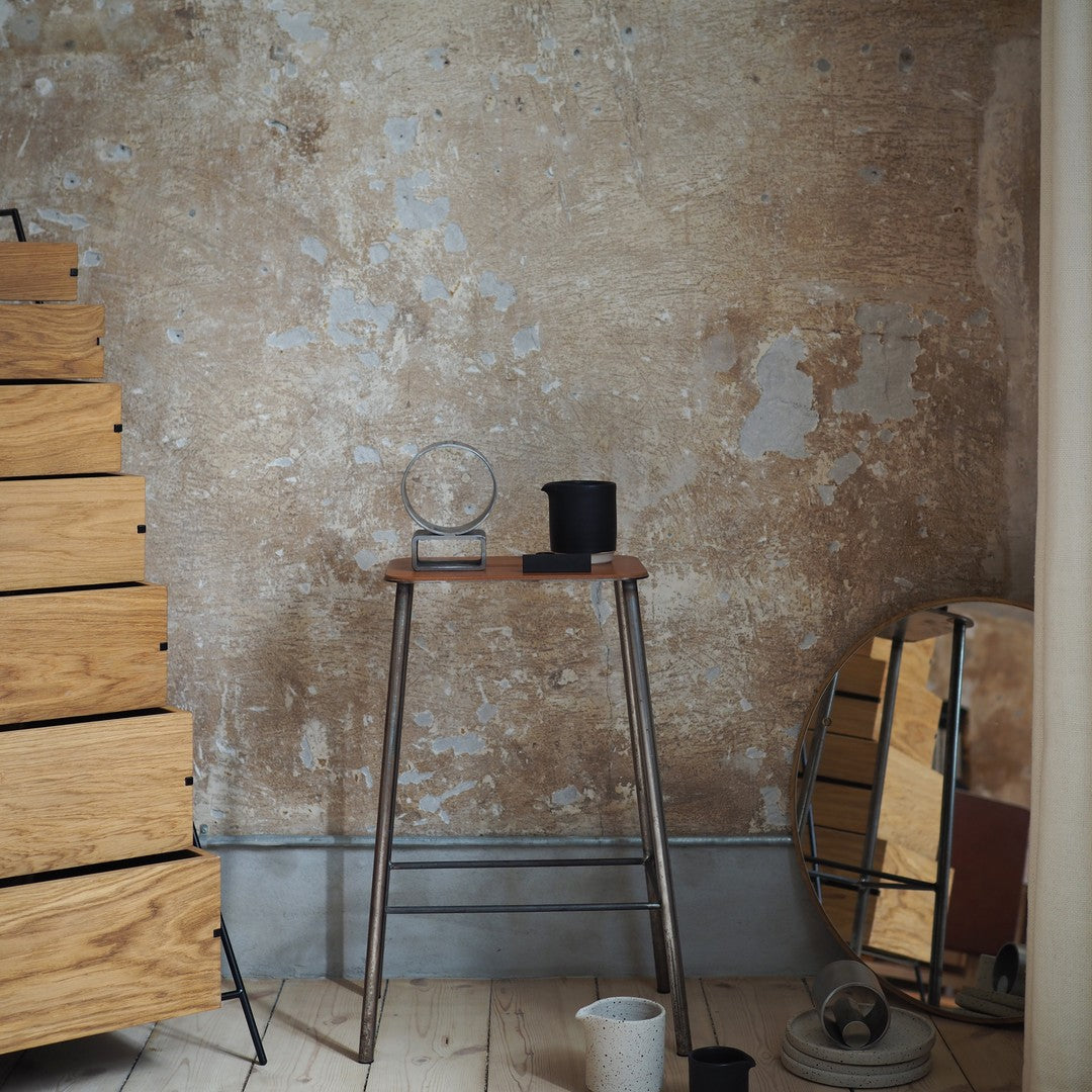 Wooden textures, rust-colored walls, and minimalistic black and clear decor on a stylish table.