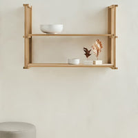 Natural wooden shelf in light beige with minimalistic white bowls and decorative plants. Clean, modern aesthetic.