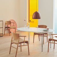Modern dining scene featuring a white oval table, warm wood tones, and a copper pendant light against soft pastel accents.