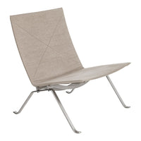 Light beige lounge chair with a smooth, minimalist design and grey metal legs, featuring a geometric pattern.