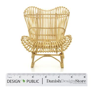 Natural rattan chair in a woven, organic design with a light beige color. Perfect for bohemian decor styling.