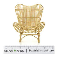 Natural rattan chair in a woven, organic design with a light beige color. Perfect for bohemian decor styling.