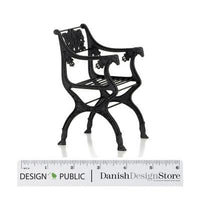 "Elegant black metal armchair with intricate patterns and a vintage design, perfect for stylish home decor."