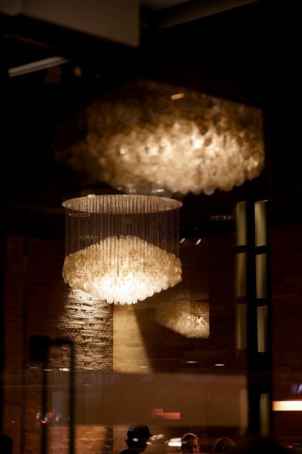 Elegant crystal chandelier with a warm golden glow, showcasing intricate patterns and reflections in a sophisticated setting.