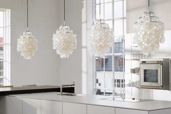 White pendant lights with a unique layered petal pattern, adding elegance to a modern kitchen interior.