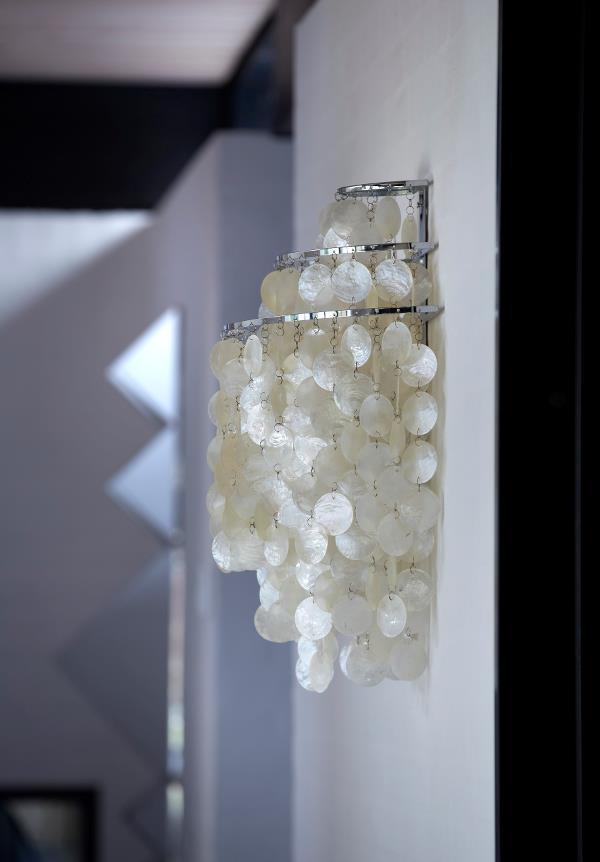White circular decor hanging on a silver rack, creating a modern and elegant pattern.