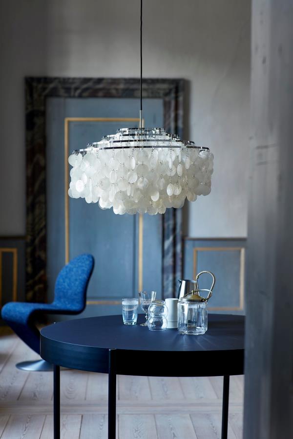 White pendant light with cloud-like pattern, modern blue chair, and dark round table in a stylish interior.