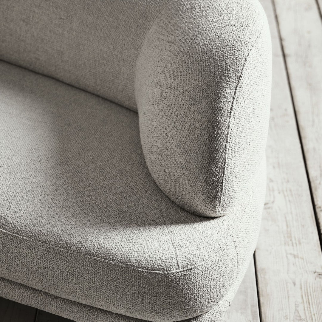 Soft gray upholstery with a textured finish, featuring a smooth, rounded armrest and minimalist design.