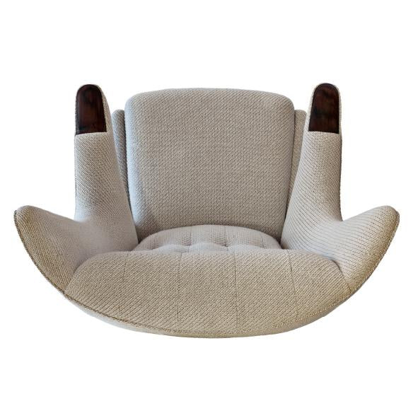 Beige upholstered chair with textured fabric and curved wooden arms, offering a modern, stylish look.