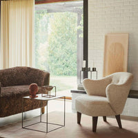 Cozy living room with a brown textured sofa and a light beige armchair, complemented by earthy tones and soft patterns.