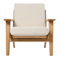 "Light beige upholstered chair with a soft, textured fabric and natural wood frame, minimalist design."