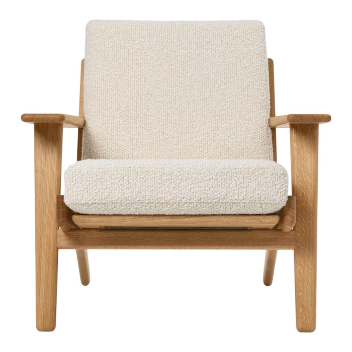 "Light beige upholstered chair with a soft, textured fabric and natural wood frame, minimalist design."