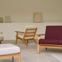Stylish wooden chairs in cream and burgundy upholstery, featuring a minimalist design in a neutral-toned setting.