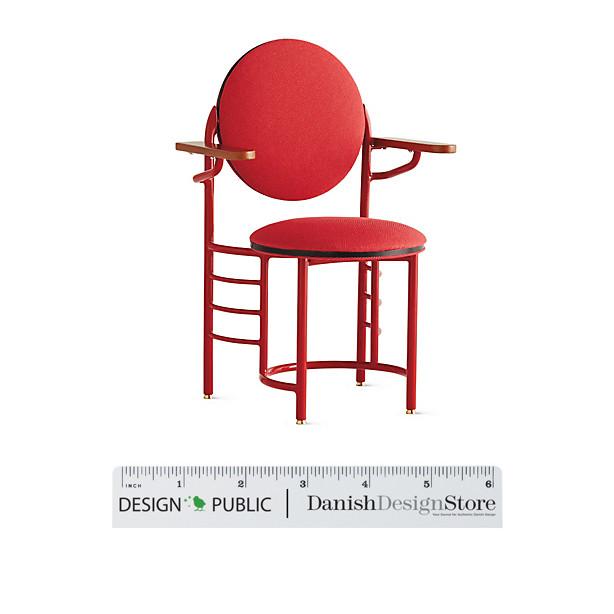 Bright red chair with circular backrest and seat, featuring sleek lines and minimalist design elements.