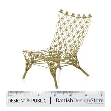 Gold wire chair with a unique woven pattern, featuring a modern, decorative design. Perfect for stylish decor.