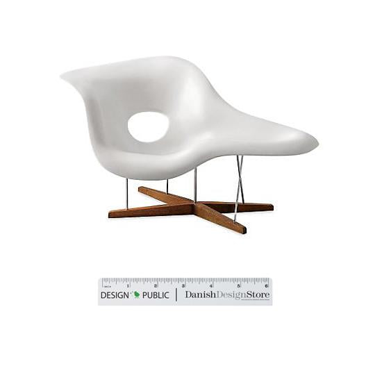 White modern chair with a smooth, curved design and natural wood legs, featuring a distinctive hole pattern.