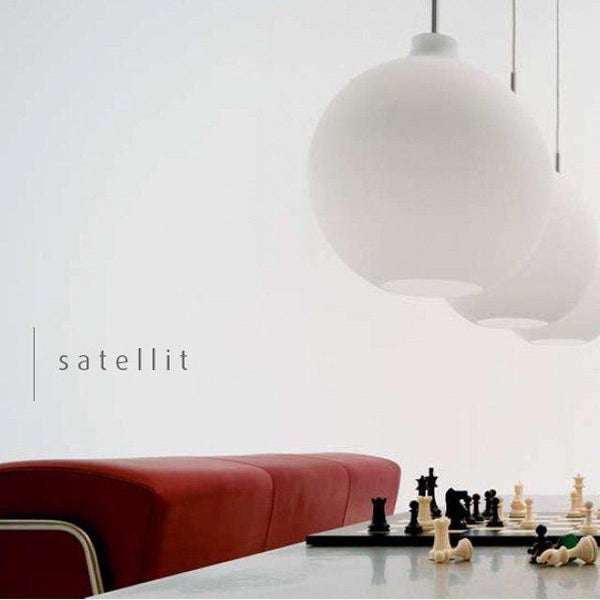 White pendant lamps hang above a sleek red sofa and a classic chess set, creating a modern and minimalist aesthetic.