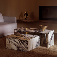 Marble coffee table with swirling black, white, and gold patterns, set in a warm, earthy-toned living space.