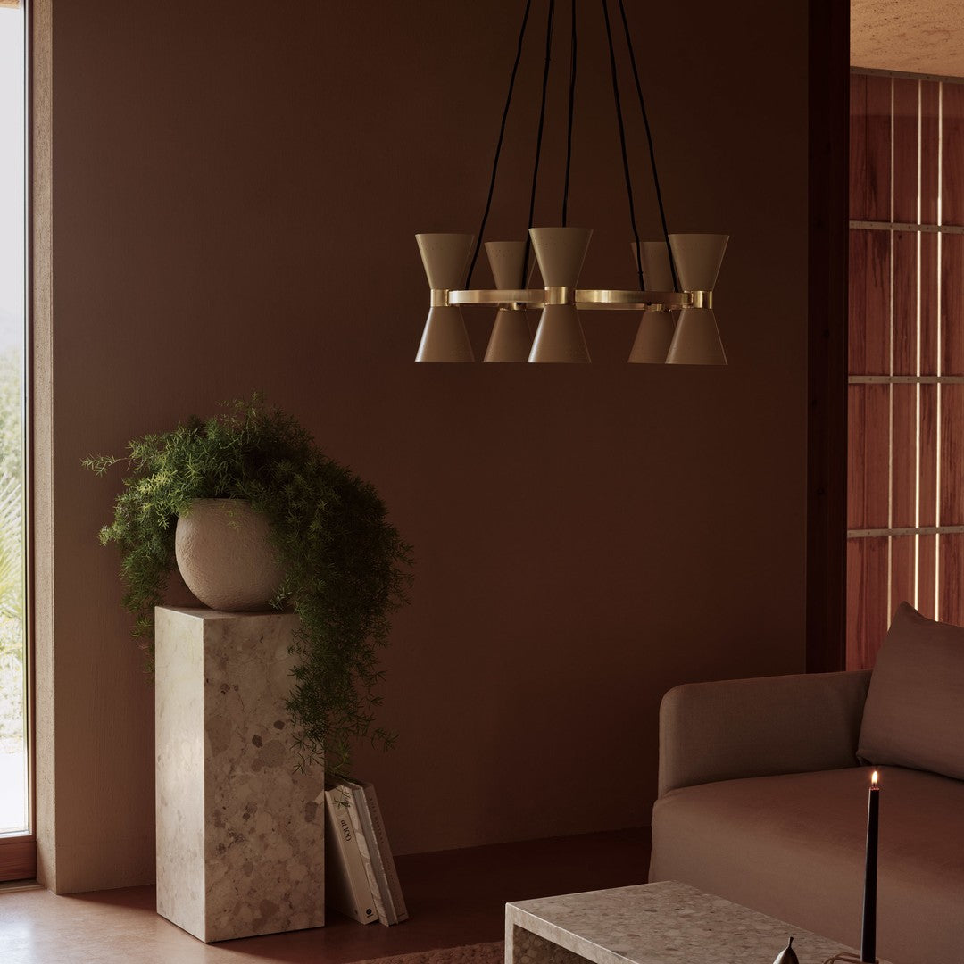 Modern pendant light in muted beige with sleek black accents, set against a warm brown backdrop.