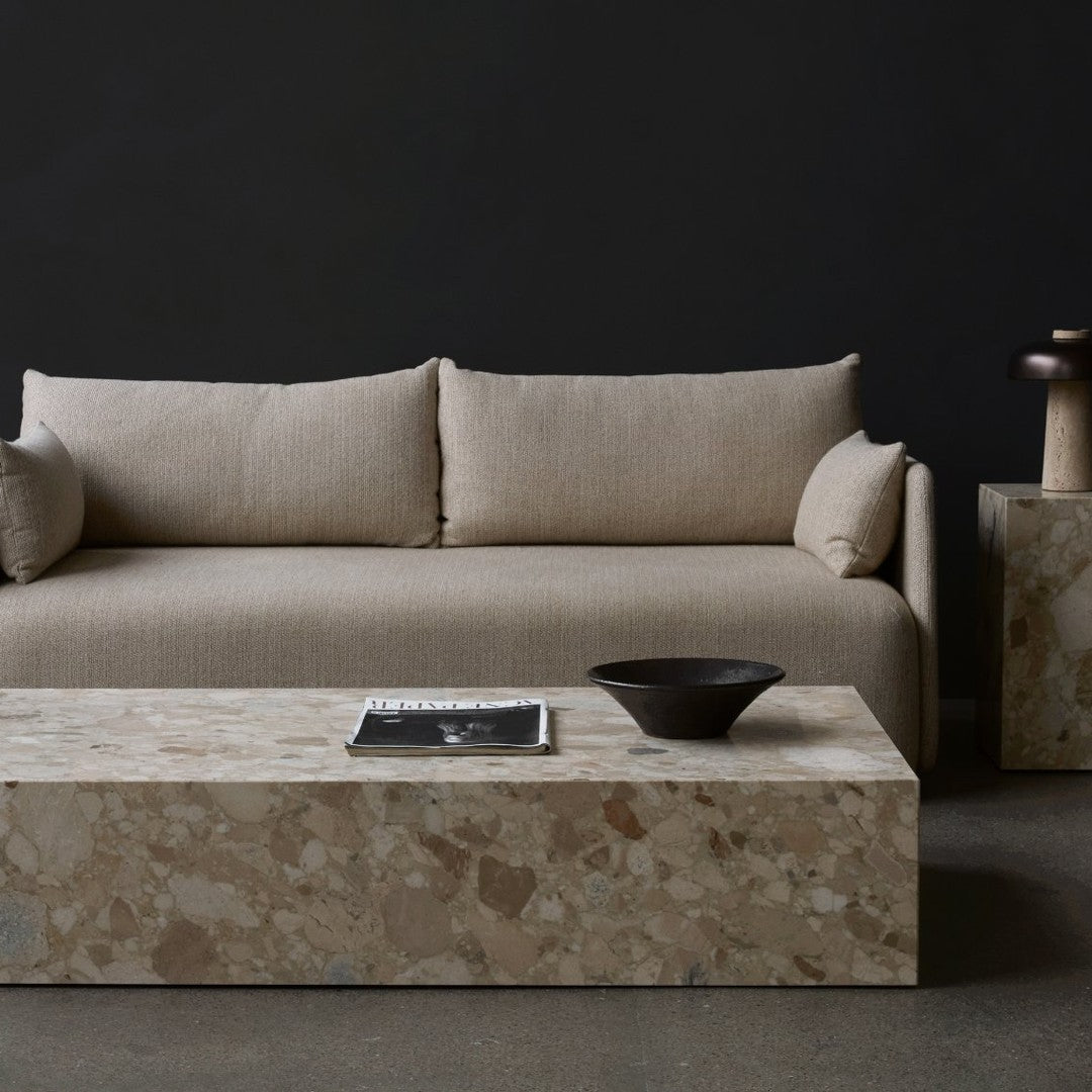 Beige linen sofa with stone coffee table, featuring a textured pattern on a dark background. Modern, minimalist aesthetic.