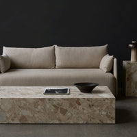 Beige linen sofa with stone coffee table, featuring a textured pattern on a dark background. Modern, minimalist aesthetic.