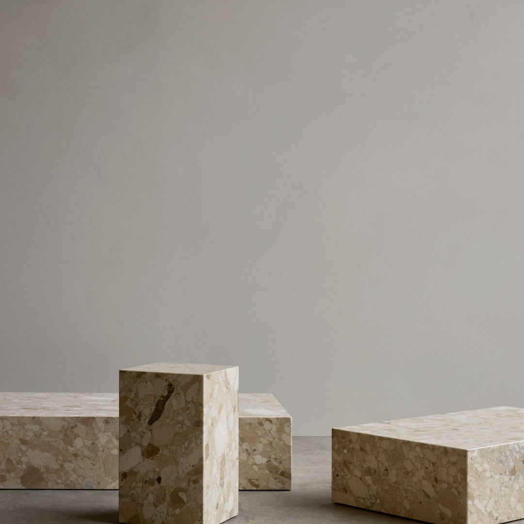 Neutral beige and cream geometric blocks with subtle speckles, set against a matte gray background.