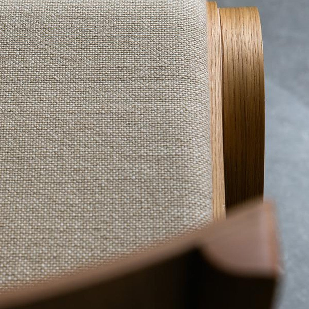 Beige textured fabric on ergonomic chair, complemented by warm wood accents, featuring clean lines and modern design.