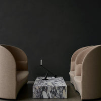 Beige curved armchairs with textured upholstery and a marble-patterned coffee table on a dark background.